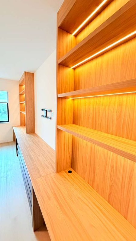 Warm office with illuminated oak shelving