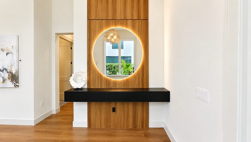 Modern entryway with illuminated circular mirror